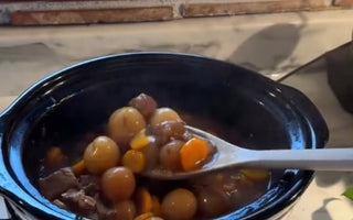Crock-Pot slow cooker with hearty stew, carrots, and potatoes on kitchen counter